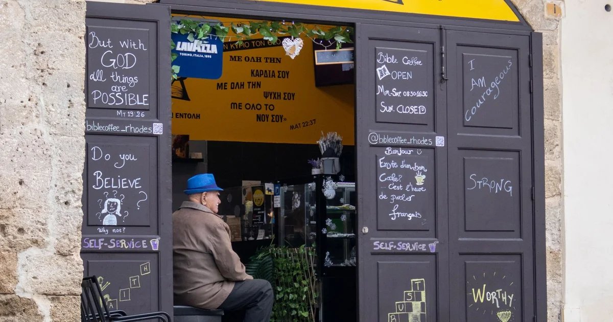 Façade d'un café de quartier avec enseigne et ardoises devant l'entrée