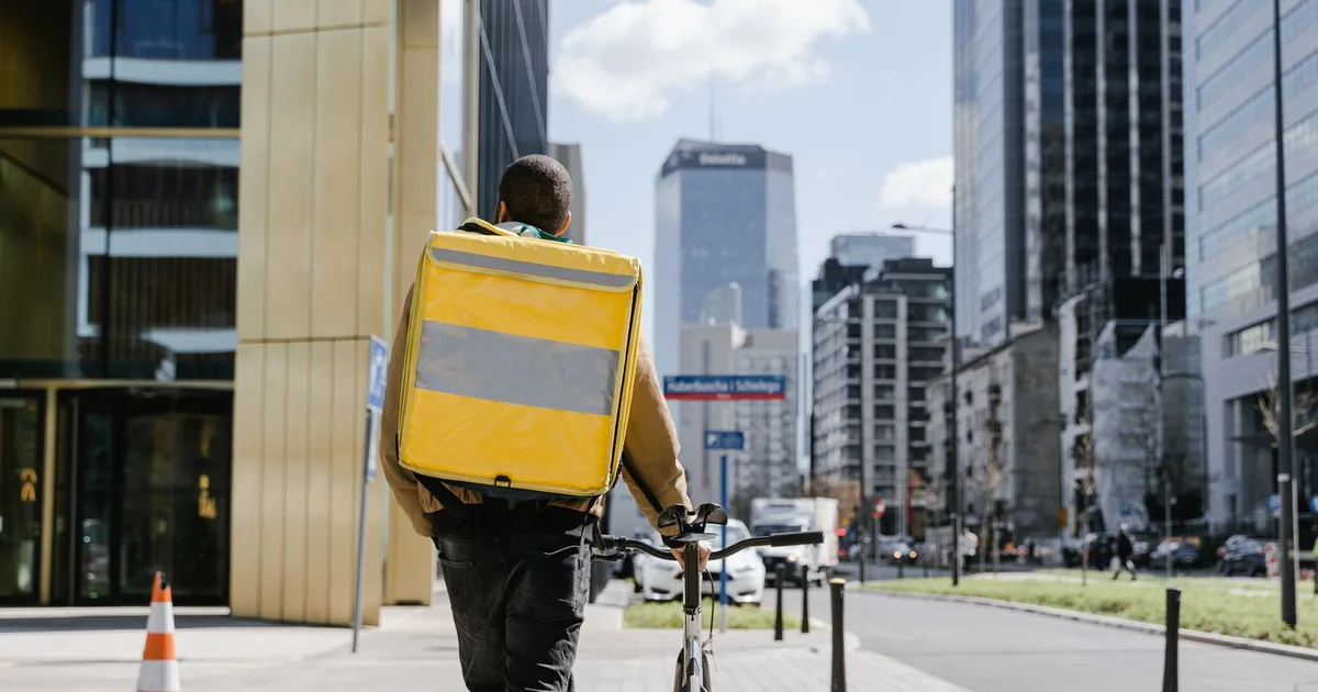 Coursier à vélo avec un grand sac isotherme jaune de livraison de repas